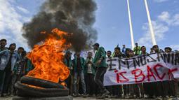Para aksi datang membawa spanduk bertuliskan “Tolak Rohingya” sambil menyanyikan lagu Buruh Tani. Aksi juga diwarnai dengan membakar ban. (CHAIDEER MAHYUDDIN/AFP)