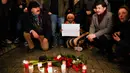 Warga menyalakan lilin saat berkabung untuk para korban penembakan brutal di Hanau di Gerbang Brandenburg Berlin, Jerman, Kamis (20/2/2020). Tersangka penembakan ditemukan tewas bersama ibunya dalam sebuah apartemen. (AP Photo/Markus Schreiber)