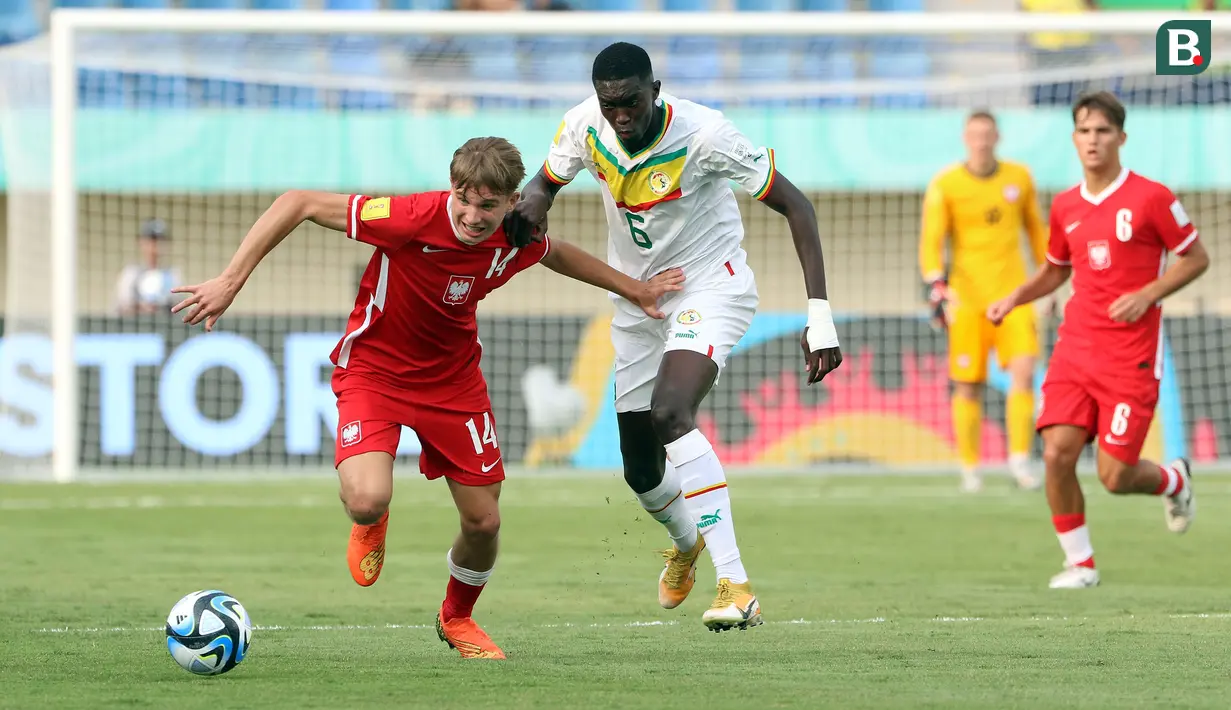 <p>Pemain Timnas Polandia U-17, Mateusz Skoczylas (kiri) berusaha melewati pemain Timnas Senegal U-17, Daouda Diong pada laga kedua Grup D Piala Dunia U-17 2023 di Stadion Si Jalak Harupat, Kabupaten Bandung, Selasa (14/11/2023). (Bola.com/Ikhwan Yanuar)</p>