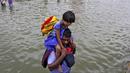 Seorang pria membawa seorang gadis melalui jalan banjir di Chennai, India, (2/11/2015). Curah hujan terparah dari satu abad telah menyebabkan banjir besar di seluruh negara bagian India Tamil Nadu. (REUTERS/Stringer)