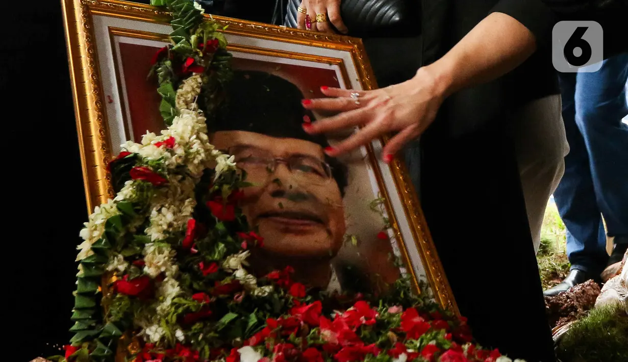 Anggota keluarga dan kerabat memegang foto mantan Menko Bidang Kemaritiman, Rizal Ramli usai proses pemakaman di tempat pemakaman umum (TPU) Jeruk Purut Jakarta, Kamis (4/1/2024). (Liputan6.com/Herman Zakharia)