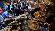 Calon pembeli memilih makanan laut kering di sebuah pasar di Kota Haikou, Provinsi Hainan, China, Rabu (15/1/2020). Warga Haikou akhir-akhir ini sibuk berbelanja untuk menyambut Tahun Baru Imlek 2020. (Xinhua/Guo Cheng)
