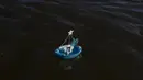Perahu kecil dengan persembahan kepada dewi laut Afrika Yemanja mengapung di air lepas Pantai Ramirez di Montevideo, Uruguay, Rabu (2/2/2022). Para pemuja mendatangi pantai pada pada hari raya Yemanja, membawa lilin, bunga, madu dan buah untuk menghormati dewi laut. (AP Photo/Matilde Campodonico)