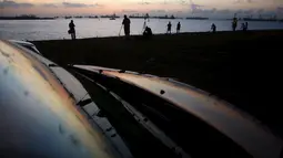  Sejumlah orang bersiap mengambil gambar fenomena alam gerhana matahari parsial di sebuah pantai di Singapura, Rabu (9/3/2016). Gerhana matahari parsial di Singapura terakhir kali terjadi pada 10 Mei 2013 lalu. (REUTERS / Edgar Su)