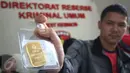 Petugas menunjukan barang bukti emas batangan dalam rilis di Polda Metro Jaya, Jakarta, Jumat (17/2). Empat kasus tersebut di usut selama periode Februari 2017 dengan mengamankan 11 orang tersangka. (Liputan6.com/Immanuel Antonius)