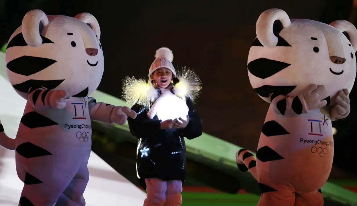 Maskot Olimpiade dan seorang gadis muda berpartisipasi dalam upacara penutupan Olimpiade Musim Dingin PyeongChang 2018 di Pyeongchang, Korea Selatan, 25 Februari 2018. (AP Photo/Natacha Pisarenko)