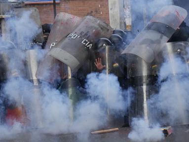 Kembang api yang dilemparkan pengunjuk rasa meledak di dekat formasi polisi saat terjadi bentrokan di dekat Kementerian Pendidikan di La Paz, Bolivia, Kamis, 13 April 2023. (AP Photo/Juan Karita)