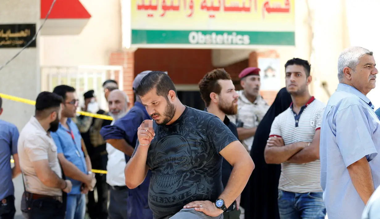 Sejumlah orang berkumpul di depan bangsal bersalin setelah insiden kebakaran di Rumah Sakit Yarmouk, Baghdad, Rabu (10/8). Berdasarkan investigasi awal, kebakaran yang menewaskan 11 bayi prematur itu disebabkan arus pendek. (REUTERS/Thaier Al - Sudani)
