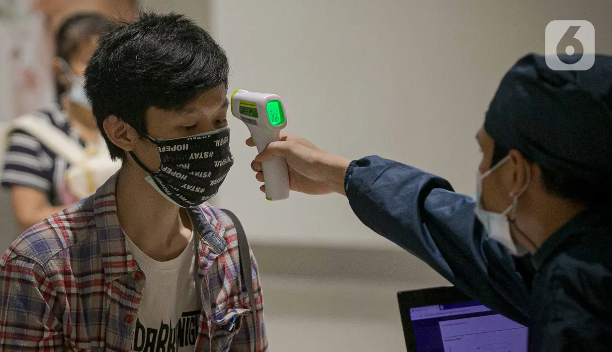Petugas kesehatan mengukur suhu tubuh pelaku UMKM di Jakarta, Kamis (1/4/2021). Vaksin diberikan kepada 1.500 pelaku UMKM dan target kanvaksinasi bagi pelaku UMKM di DKI Jakarta mencapai 250.000. (Liputan6.com/Faizal Fanani)