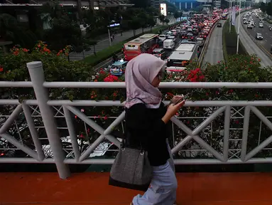 Warga melintasi Jembatan Penyeberangan Orang (JPO) di Jakarta, Kamis (31/8/2023). (Liputan6.com/Johan Tallo)