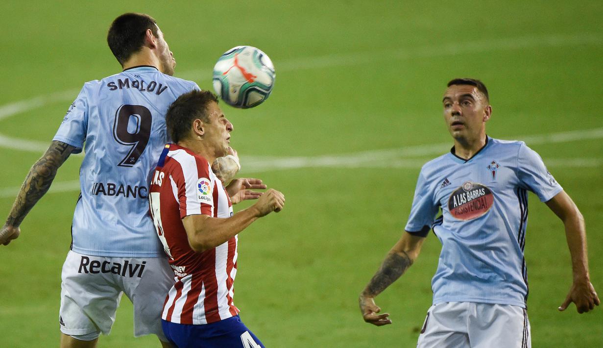 Bek Atletico Madrid, Santiago Arias, berebut bola dengan penyerang Celta Vigo, Smolov, pada laga lanjutan La Liga di Abanca-Balaidos, Rabu (8/7/2020) dini hari WIB. Atletico Madrid ditahan imbang 1-1 oleh Celta Vigo. (AFP/Miguel Riopa)
