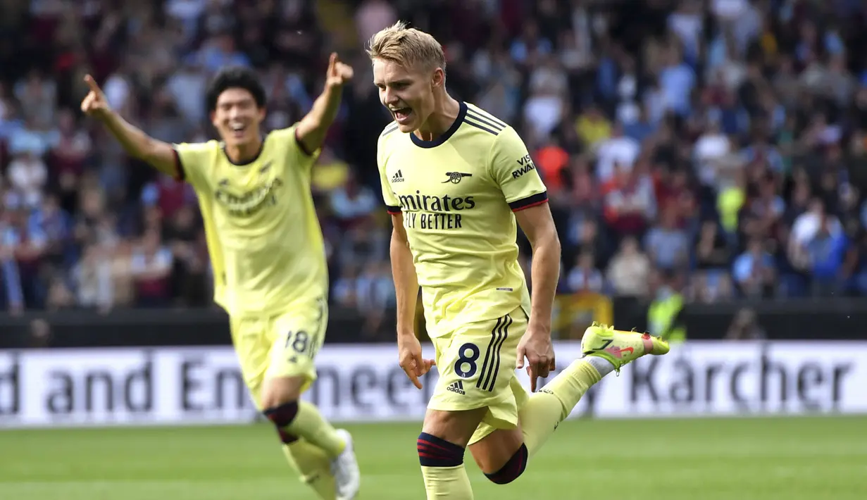 Arsenal pun unggul 1-0 setelah tendangan bebas langsung kaki kiri Martin Odegaard melesat mulus ke sisi kanan atas gawang Nick Pope. (PA via AP/Anthony Devlin)