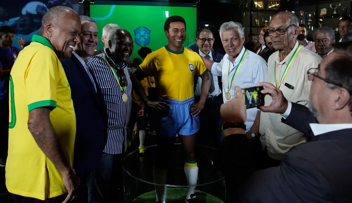Mantan legenda sepakbola Brasil, Dario (kiri) dan Presiden CBF Rogerio Caboclo berfoto dengan patung Pele di Museum Tim Sepak Bola Brasil di Rio de Janeiro, Kamis (20/2/2020). Patung Pele diluncurkan sebagai bagian dari peringatan 50 tahun sejak kemenangan Piala Dunia 1970. (AP/Leo Correa)