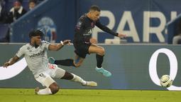 Penyerang Paris Saint-Germain (PSG) Kylian Mbappe melepaskan diri dari bek Reims Yunis Abdelhamid dalam matchday ke-22 Liga Prancis 2021/2022 di Parc des Princes, Senin (24/1/2022) dini hari WIB. PSG menang telak 4-0 atas Reims. (AP Photo/Francois Mori)
