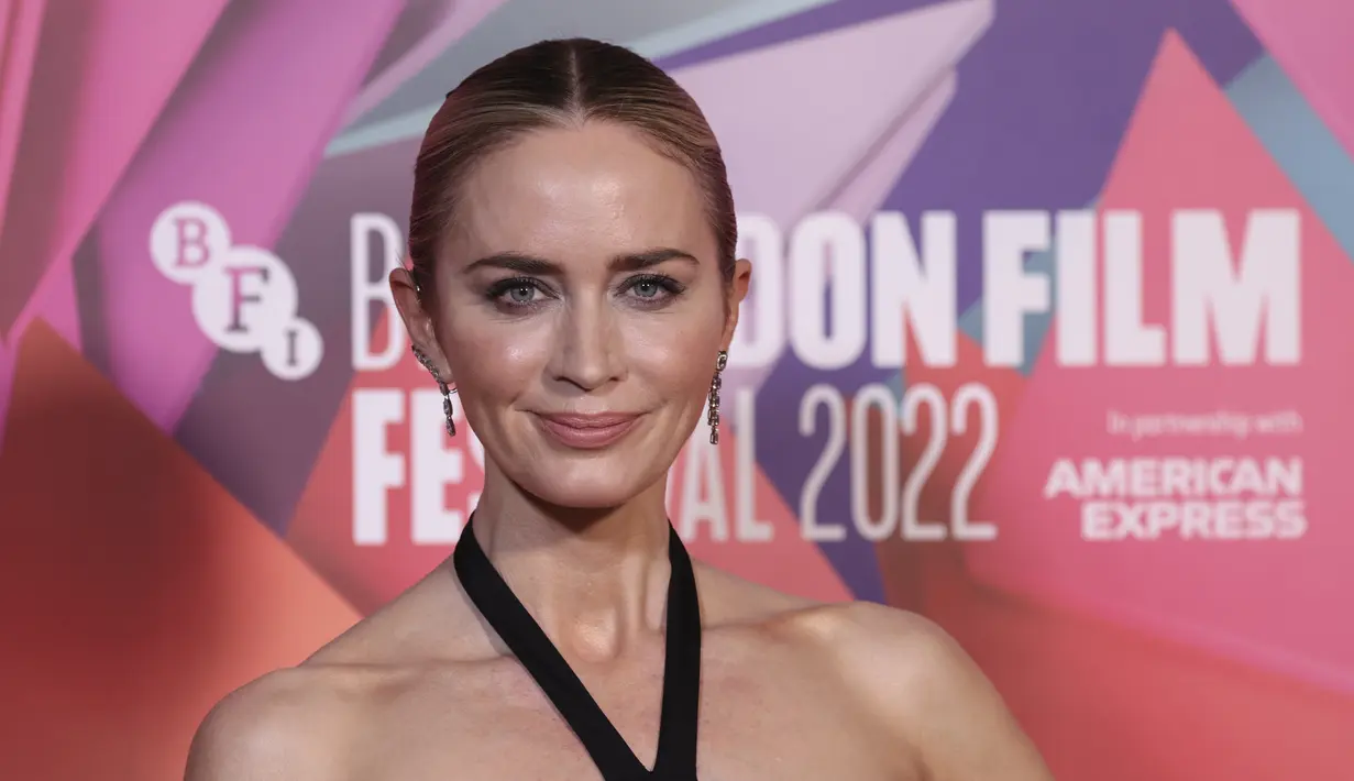 Emily Blunt berpose di depan fotografer saat tiba untuk pemutaran perdana film 'The English' selama Festival Film London 2022 di London, Sabtu, 15 Oktober 2022. Ansambel leher halter bintang layar Emily dilengkapi dengan gelang tebal yang dikenakannya di pergelangan tangannya dengan warna yang sama dengan gaunnya. (Photo by Vianney Le Caer/Invision/AP)