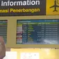 Calon penumpang mengambil gambar papan informasi penundaan penerbangan di Bandara Ngurah Rai, Bali, Jumat (29/6). Pihak pengelola menutup sementara aktivitas bandara maupun penerbangan karena gangguan abu vulkanis erupsi Gunung Agung. (AFP/GEDE ARDIASA)