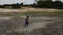 Perahu dan rumah perahu terjebak di daerah kering di Sungai Negro selama kekeringan di Manaus, negara bagian Amazonas, Brasil, Senin, 16 Oktober 2023.  (AP Photo/Edmar Barros)
