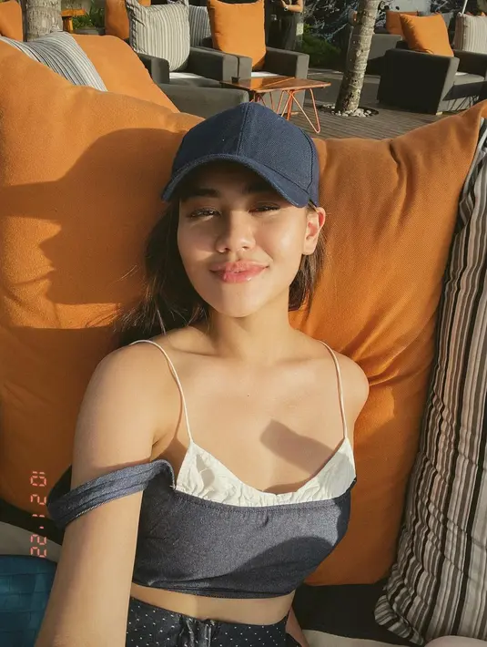 Potret glowingnya Aaliyah Massaid berjempur di bawah sinar matahari. Ia mengenakan outfit minimalis berupa tank top bertali spageti yang unik dipadu topi yang serasi. [Foto: Instagram/aaliyah.massaid]
