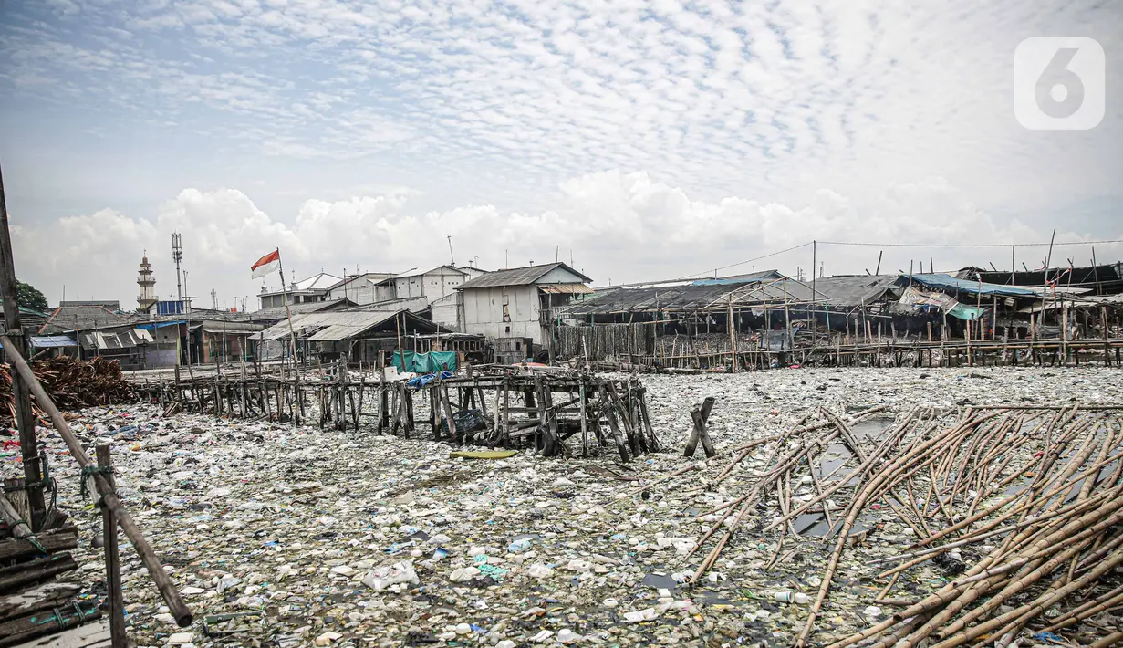 Suasana jembatan kayu di antara sampah di perkampungan nelayan Cilincing, Jakarta, Minggu (21/2/2022). Peringatan HPSN 2022, Pemprov DKI Jakarta mengajak warga Jakarta untuk peduli sampah mulai dari lingkungan terdekat minimal dengan cara memilah sampah dari rumah. (Liputan6.com/Faizal Fanani)