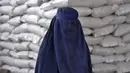 <p>Seorang perempuan Afghanistan menunggu untuk menerima jatah makanan yang didistribusikan oleh kelompok bantuan kemanusiaan Korea Selatan, di Kabul, Selasa (10/5/2022). Taliban pada Sabtu pekan lalu memerintahkan semua perempuan Afghanistan menutupi seluruh tubuhnya atau mengenakan burqa tradisional di depan umum. (AP Photo/Ebrahim Noroozi)</p>