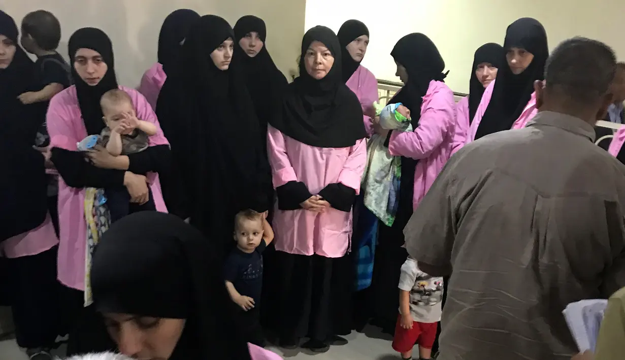 Sejumlah wanita Rusia yang diduga bergabung dengan ISIS dikumpulkan di Baghdad Central Criminal Court, Irak (29/4). Irak menghukum penjara seumur hidup 19 wanita Rusia karena bergabung dengan ISIS. (AFP/Ammar Karim)