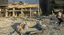 Seorang pria berjalan melewati bangunan yang hancur dan rusak di lokasi serangan udara Israel semalam yang menargetkan pinggiran selatan Beirut pada 27 Oktober 2024. (Foto oleh AFP)