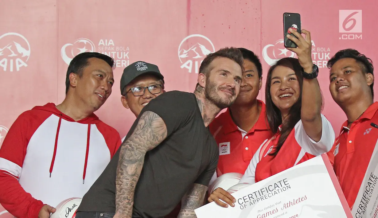 Perwakilan Atlet Asian Games Indonesia dan Menpora Imam Nahrawi swafoto bersama mantan bintang sepak bola Inggris David Beckham pada acara AIA Sepak Bola untuk Negeri di Jakarta, Minggu (25/3). (Liputan6.com/Herman Zakharia)