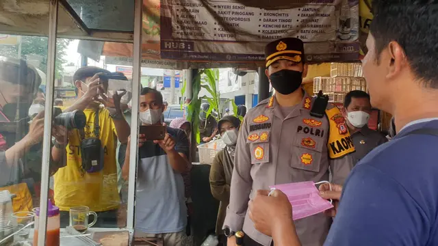 Kapolres Garut AKBP Wirdhanto Hadicaksono saat berbicara dengan penjual gorengan Pasar Lewo Malangbong, Garut, Jawa Barat mengenai minyak goreng.