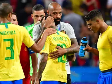 Asisten pelatih Belgia Thierry Henry (kedua kanan) memeluk striker Brasil, Neymar pada akhir laga perempat final Piala Dunia 2018 di Stadion Kazan Arena, Jumat (6/7). Timnas Brasil takluk 1-2 di tangan timnas Belgia. (Luis Acosta/AFP)
