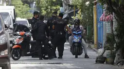 Polisi berbicara dengan seorang warga di sebuah desa yang dikunci karena jumlah kasus COVID-19 di antara warga di Manila, Filipina (11/3/2021). Polisi juga tidak mengizinkan kedua hotel itu selama tiga hari penguncian dan pelanggar akan dipaksa menjalani karantina 14 hari. (AP Photo/Aaron Favila)