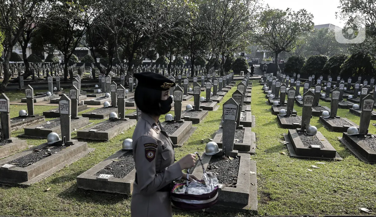 Anggota Polri membawa bunga saat ziarah ke Taman Makam Pahlawan Nasional Utama (TMPNU) Kalibata, Jakarta, Senin (29/6/2020). Kegiatan tersebut dilakukan dalam rangka rangkaian peringatan HUT ke-74 Bhayangkara yang jatuh pada 1 Juli 2020. (Liputan6.com/Johan Tallo)