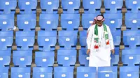 Seorang pendukung Arab Saudi berdiri di tengah tribun penonton usai laga melawan Uruguay pada pertandingan kedua Grup A Piala Dunia 2018 di Rostov Arena, Rabu (20/6). Kalah 0-1, Arab Saudi menjadi tim kedua yang tersingkir setelah Maroko. (AFP/JOE KLAMAR)