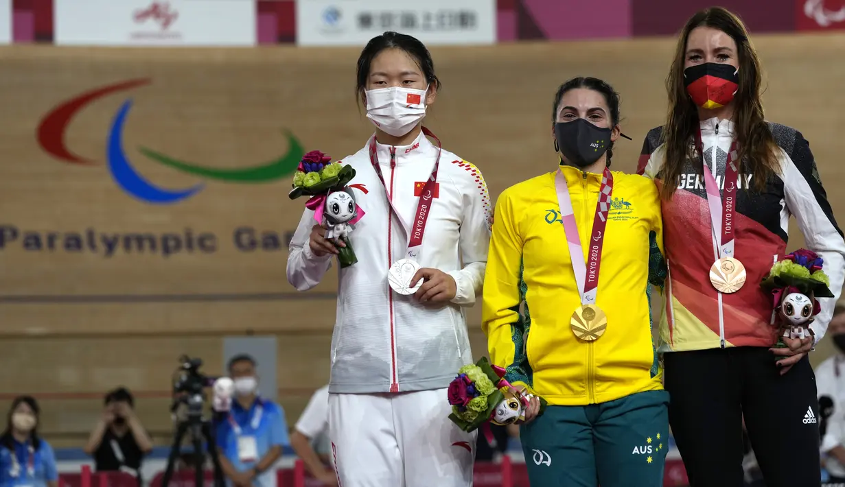 Atlet balap sepeda Australia, Paige Greco (tengah) memegang medali emas bersama peraih medali perak Wang Xiaomei dari China dan peraih medali perunggu Denise Schindler dari Jerman seusai kompetisi nomor C1-3, 3000 m pursuit putri Paralimpiade Tokyo 2020 di Izu, Rabu (25/8/2021). (AP/Shuji Kajiyama)