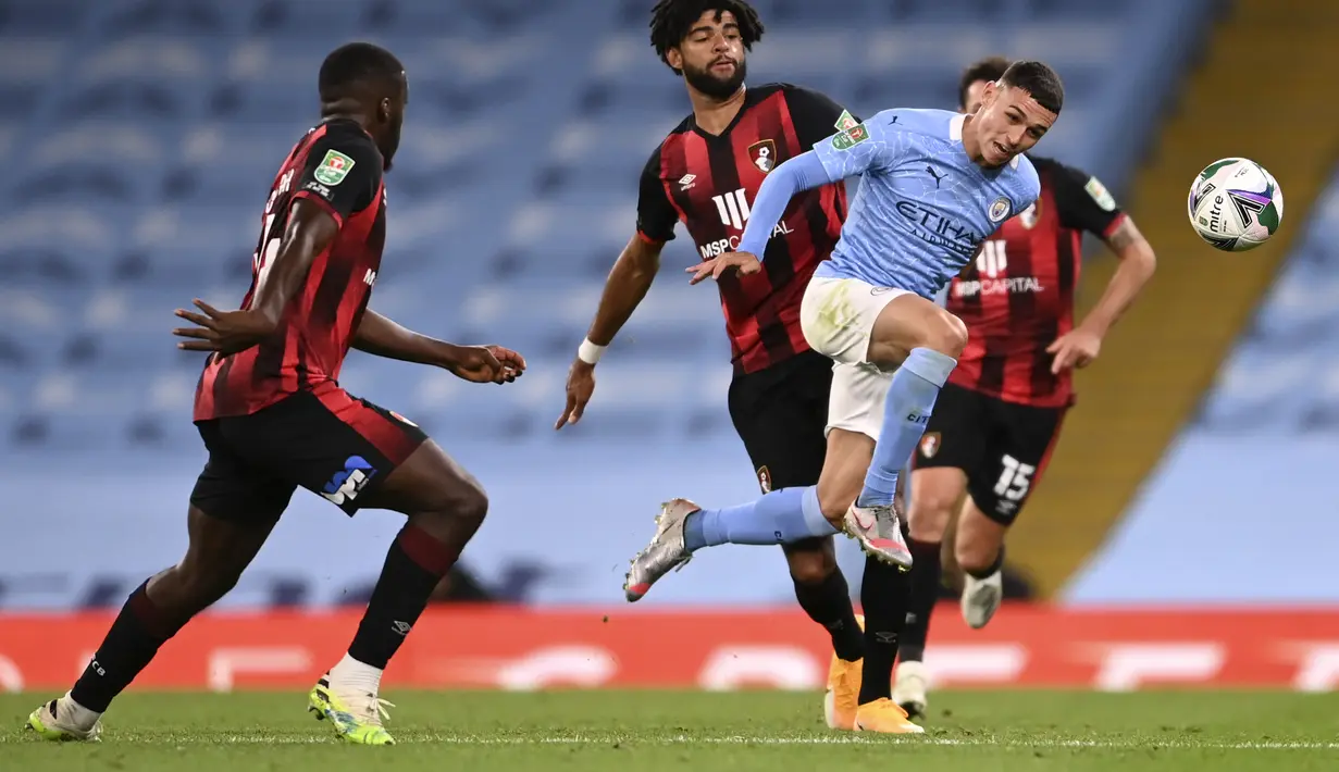 Gelandang Manchester City, Phil Foden berusaha mengejar bola dari kawalan dua pemain Bournemouth pada pertandingan putaran ketiga Piala Liga Inggris di City of Manchester Stadium di Manchester, Inggris, Kamis (24/9/2020). City menang tipis atas Bournemouth 2-1. (Laurence Griffiths/Pool via AP)