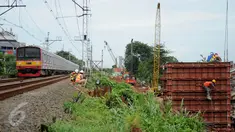  Kereta milintas di dekat proyek pembangunan jalur dua rel ganda atau double-double track (DDT) Manggarai-Cikarang, Jakarta, Jumat (13/1). Menhub mengungkapkan, kendala proyek DDT ini adalah administrasi pembebasan lahan. (Liputan6.com/Gempur M Surya)