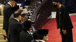 Presiden Joko Widodo atau Jokowi (kanan) memberi salam saat mengikuti Sidang Paripurna DPR 2021 di Gedung Nusantara, Senayan, Jakarta, Senin (16/8/2021). Jokowi membacakan RUU APBN 2022 dan Nota Keuangan. (Liputan6.com/Angga Yuniar)