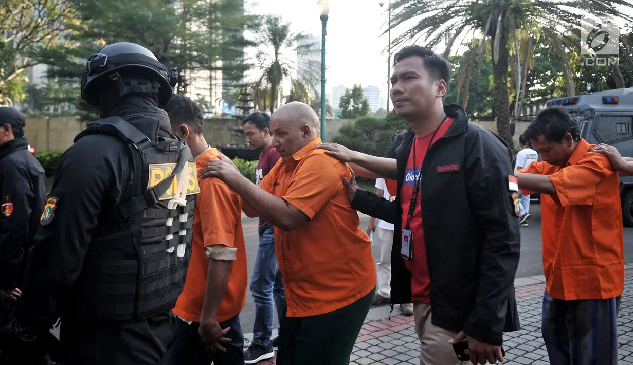 Polisi menggiring tersangka kasus ambulans Partai Gerindra membawa batu dalam Aksi 22 Mei saat rilis di Mapolda Metro Jaya, Jakarta, Kamis (23/5/2019). Polisi menangkap 11 tersangka dalam kasus ini. (merdeka.com/Iqbal Nugroho)