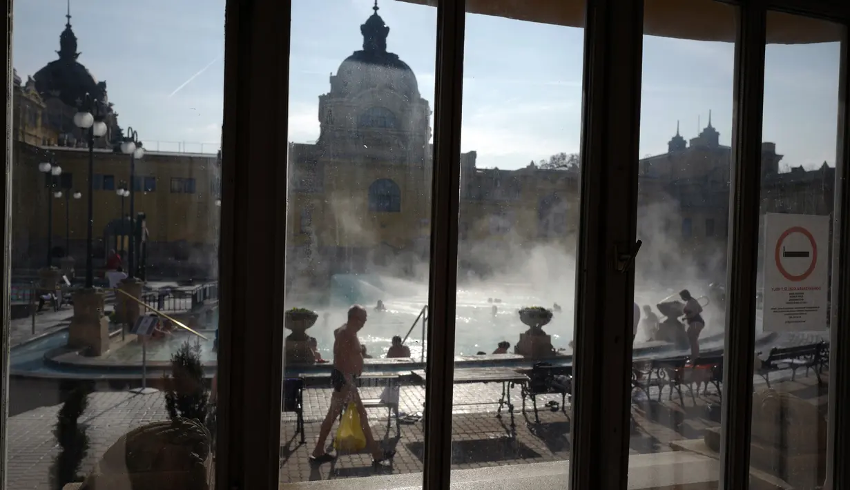 Para pengunjung menikmati air hangat di kolam relaksasi Szechenyi, di Budapest, Hongaria pada 15 Februari 2019. Szechenyi Thermal Bath adalah salah satu lokasi pemandian umum tertua dan terbesar di Budapest. (VALERY HACHE / AFP)