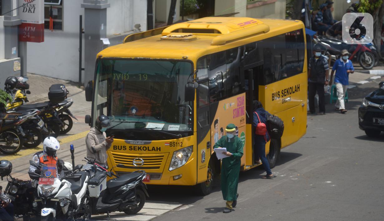 Bus sekolah menjemput pasien Covid-19 berstatus orang tanpa gejala (OTG) di Puskesmas Jatinegara, Jakarta, Selasa (22/9/2020). Sejumlah unit bus sekolah kini dialihfungsikan menjadi kendaraan untuk mengantar pasien Covid-19 berstatus OTG menuju RS Darurat Wisma Atlet. (merdeka.com/Imam Buhori)