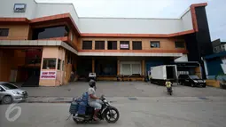 Pengendara motor melintas di depan salah satu pabrik pengolahan ikan yang tutup di Pelabuhan Muara Baru, Jakarta, Senin (10/10). Pengusaha perikanan Muara Baru melakukan mogok massal dan menghentikan kegiatan operasionalnya. (Liputan6.com/Gempur M Surya)