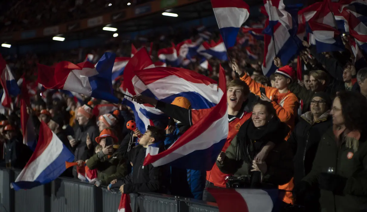 Suporter Belanda mengibarkan bendera negaranya saat pertandingan Grup B Kualifikasi Euro 2024 antara Timnas Belanda melawan Timnas Gibraltar di Feyenoord Stadium, Rotterdam, Belanda, Selasa (28/03/2023) WIB. De Oranje menang dengan skor 3-0. (AP Photo/Peter Dejong)