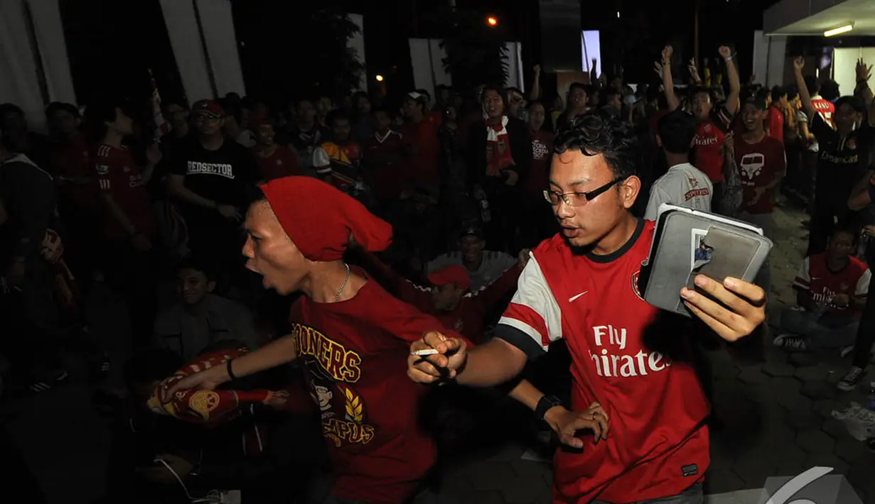 Suporter Arsenal bersorak gembira saat tim kesayangan mereka berhasil menjebol gawang lawan, Jakarta, Minggu ( 21/12/2014)(Liputan6.com/Miftahul Hayat)