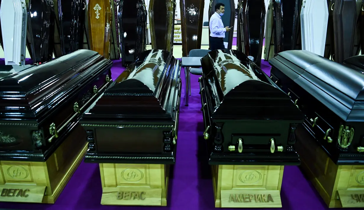 Seorang pria berjalan di antara peti mati selama pameran pemakaman di Moskow, Rusia pada Rabu (21/10/2020). (Photo by Kirill KUDRYAVTSEV / AFP)