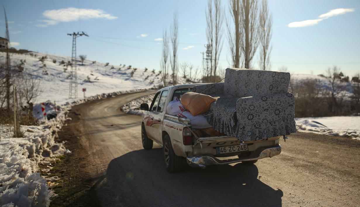 Sebuah mobil meninggalkan desa Buyuknacar di Kahramanmaras, Turki, Rabu, 15 Februari 2023. Lebih dari 35.000 orang tewas di Turki akibat gempa minggu lalu, menjadikannya bencana paling mematikan sejak negara itu didirikan 100 tahun lalu. (AP Photo/Emrah Gurel)