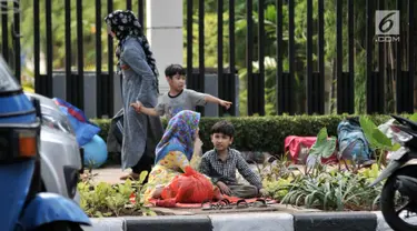 Sejumlah imigran duduk di trotoar depan Kantor UNHCR Menara Ravindo, Kebon Sirih, Jakarta, Rabu (3/7/2019). Puluhan imigran yang sebelumnya menetap di Kalideres kini terlantar di trotoar depan Menara Ravindo. (merdeka.com/Iqbal Nugroho)