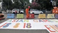 Pekerja dari PPSU Kelurahan Pegangsaan saat menyelesaikan pembuatan maskot dan logo Asian Games 2018 di Jalan Penataran atau Simpang Tugu Proklamasi, Jakarta, Rabu (25/7).  (Merdeka.com/Iqbal S. Nugroho)