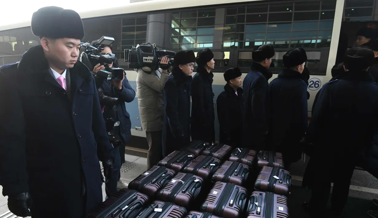 Rombongan grup orkestra Korut merapihkan koper saat tiba di kantor transit Korea di DMZ di Paju (5/2). Korut mengirim rombongan seni Samjiyon beranggota 140 orang ke Selatan untuk dua konser di ibukota Seoul dan di Gangneung. (AFP Photo/Pool/Jung Yeon-Je)