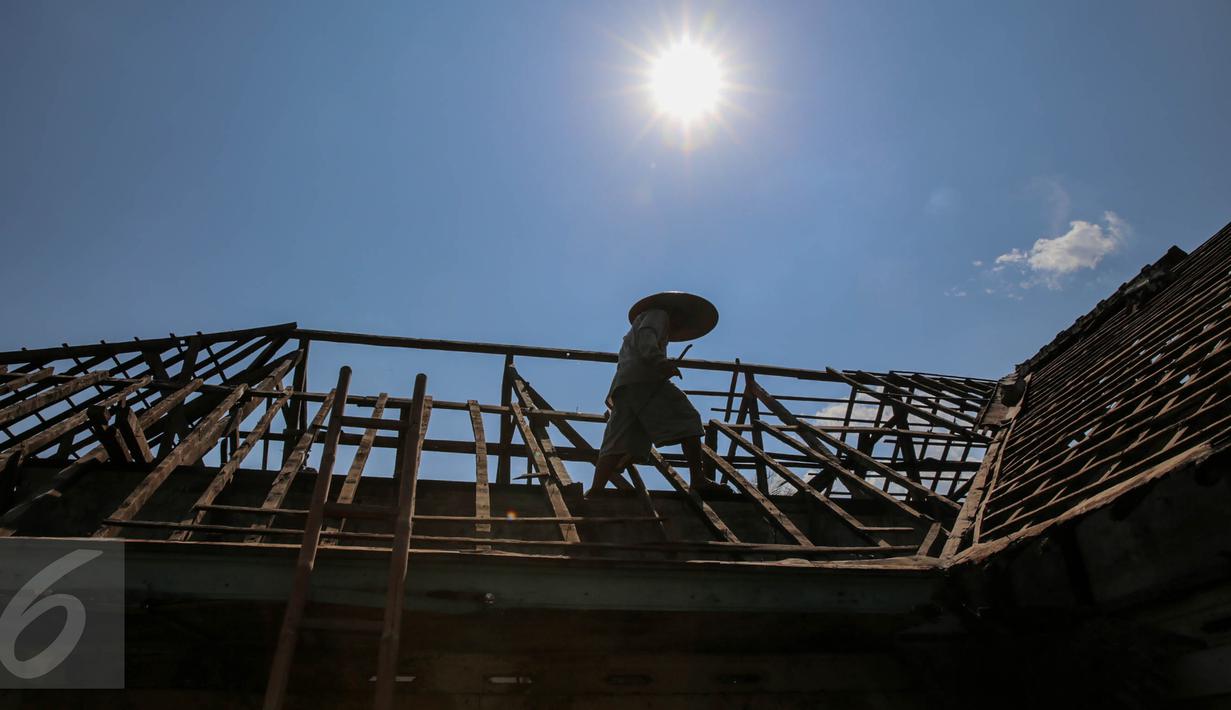Warga membongkar sendiri rumah yang akan terkena dampak penggenangan Waduk Jatigede di Desa Cipaku, Sumedang, Jawa Barat, Senin (31/8/2015). Beberapa warga masih ada yang bertahan karena belum tuntasnya soal ganti rugi. (Liputan6.com/Faizal Fanani)