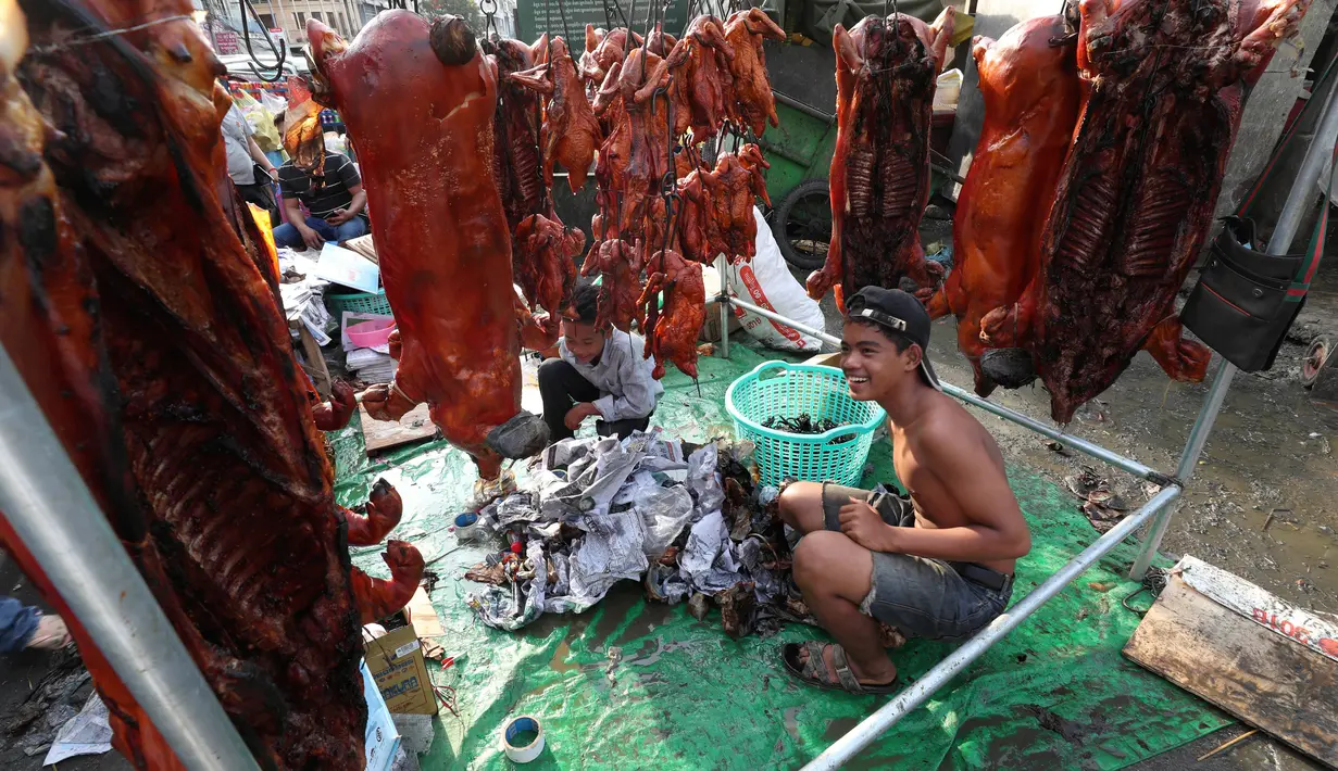 Pedagang menyiapkan babi panggang untuk perayaan Tahun Baru Imlek di Phnom Penh, Kamboja, Jumat (24/1/2020). Sejumlah pedagang di Phnom Penh sudah menjajakan daging babi panggang untuk perayaan Imlek. (AP photo/Heng Sinith)