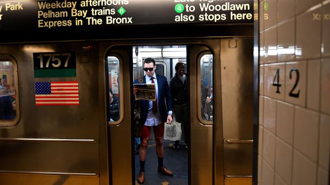 Peserta acara tahunan No Pants Subway Ride melakukan perjalanan dengan kereta bawah tanah di New York pada Minggu (12/1/2020). Untuk tahun ini, acara naik kereta tanpa celana itu dilangsungkan serentak di sejumlah kota dunia pada 12 Januari. (Johannes EISELE / AFP)